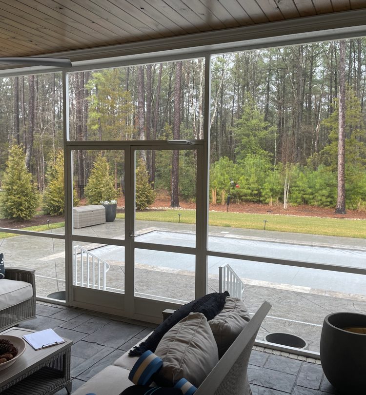 Before image showing screened porch with outdoor furniture prior to Turnkey Porch Enclosure installation.